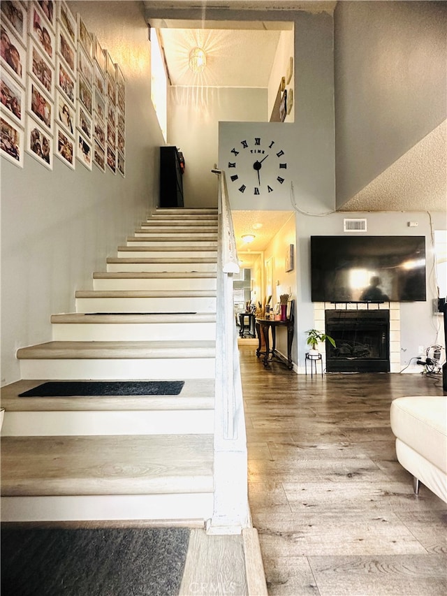 staircase with hardwood / wood-style flooring and a textured ceiling