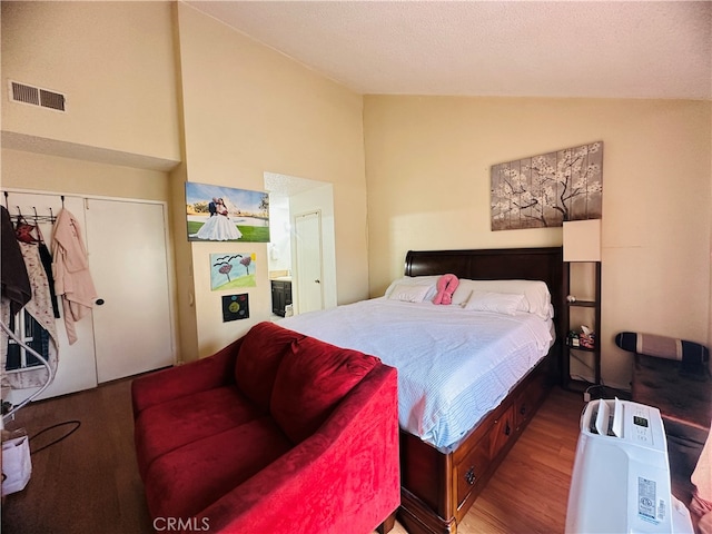 bedroom with wood-type flooring, a closet, and high vaulted ceiling