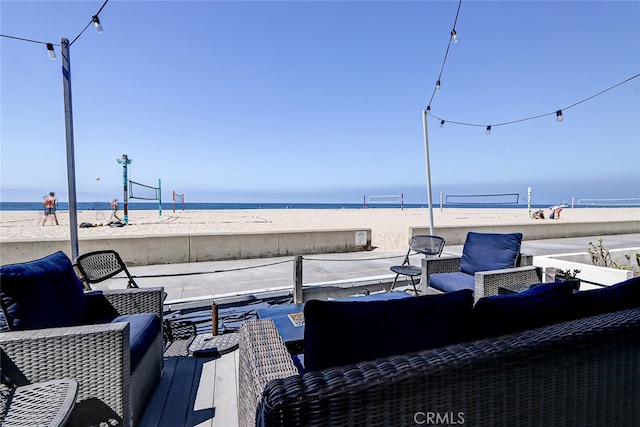 exterior space featuring a view of the beach, a water view, and an outdoor living space