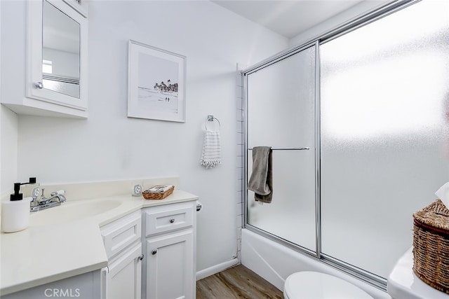 full bathroom with bath / shower combo with glass door, vanity, toilet, and a healthy amount of sunlight