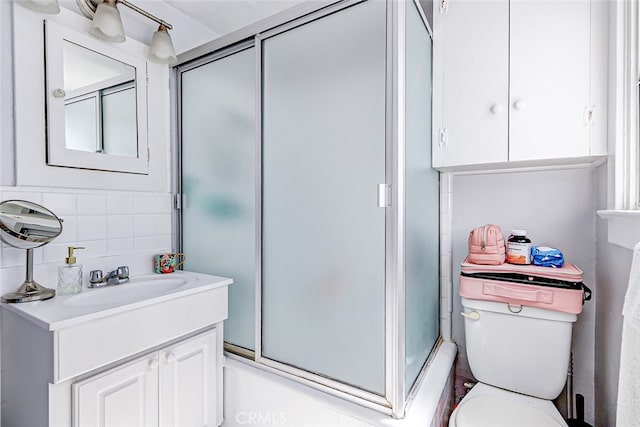 bathroom with an enclosed shower, backsplash, vanity, and toilet