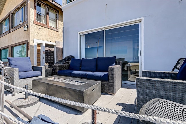 view of patio with an outdoor living space with a fire pit and a deck