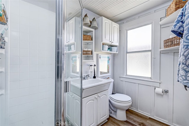 bathroom with vanity, hardwood / wood-style flooring, wooden ceiling, walk in shower, and toilet