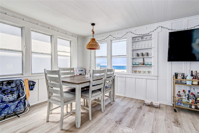 dining room featuring built in features, light hardwood / wood-style floors, and wood ceiling