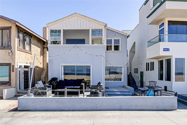 rear view of property featuring an outdoor living space, a patio, and a balcony