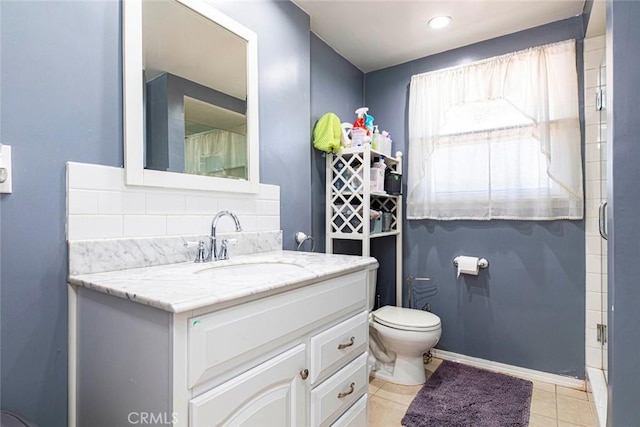 bathroom featuring vanity, tile patterned floors, toilet, tasteful backsplash, and a shower with shower door