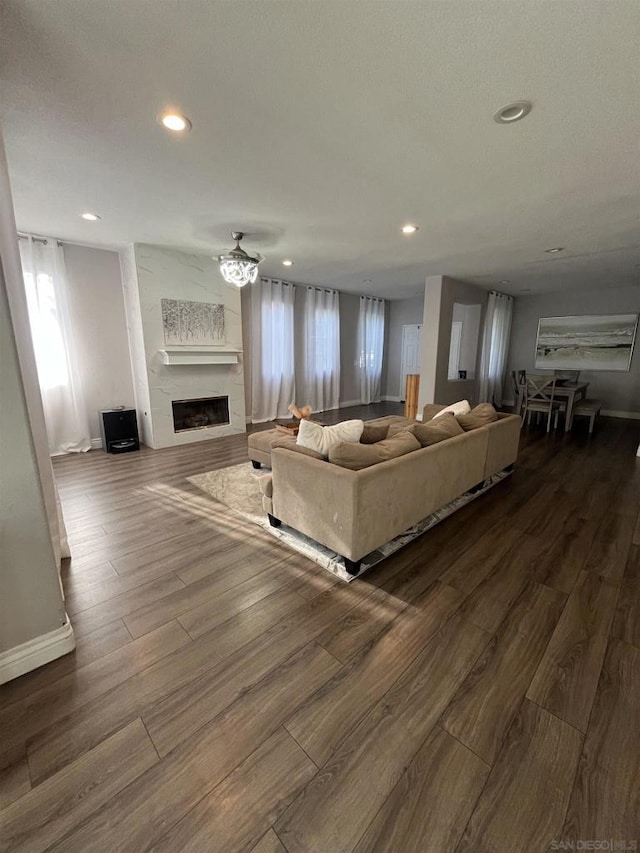 living room featuring hardwood / wood-style flooring, a large fireplace, and ceiling fan