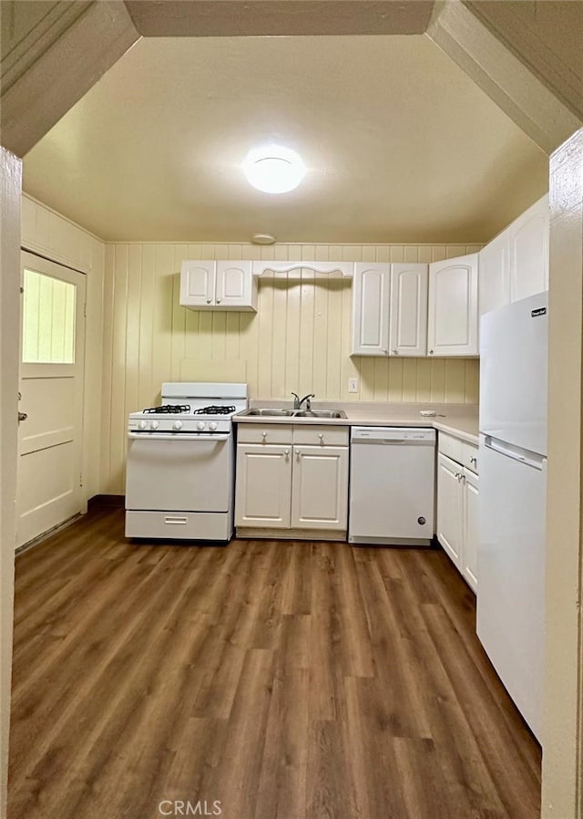 kitchen featuring white cabinets, sink, white appliances, dark hardwood / wood-style floors, and vaulted ceiling