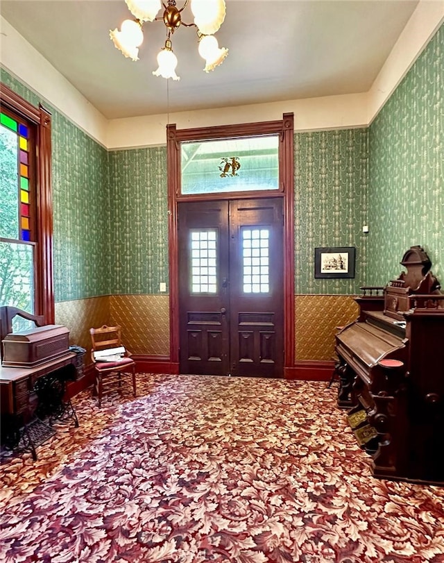 entryway featuring carpet floors and a notable chandelier