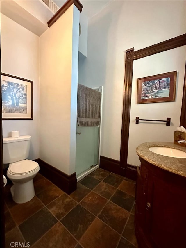 bathroom featuring vanity, toilet, and a shower with door