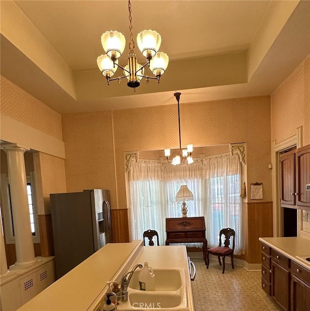 kitchen with pendant lighting, a chandelier, decorative columns, and stainless steel fridge with ice dispenser