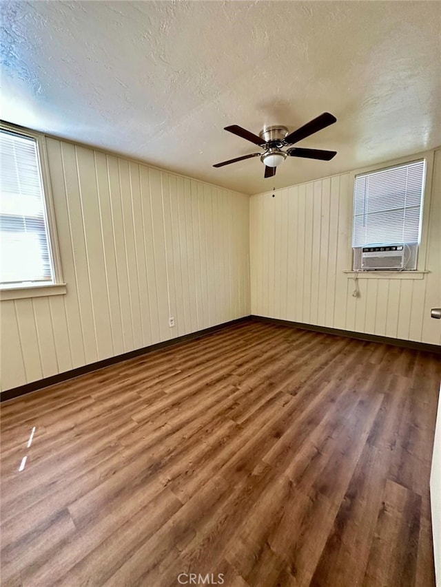 additional living space featuring ceiling fan, cooling unit, hardwood / wood-style flooring, and a textured ceiling