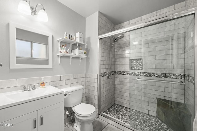 bathroom featuring tile patterned flooring, an enclosed shower, toilet, vanity, and tile walls