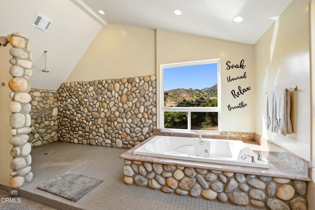 bathroom featuring vaulted ceiling with beams and a washtub