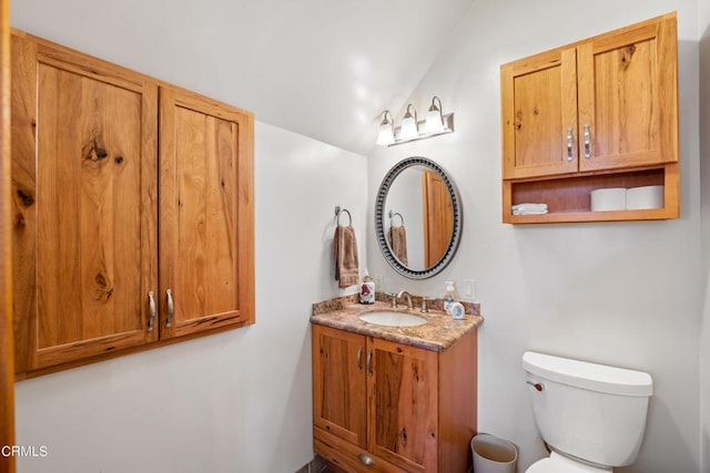 bathroom with vaulted ceiling, toilet, and vanity