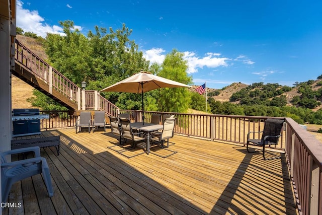 wooden deck with a mountain view and a grill