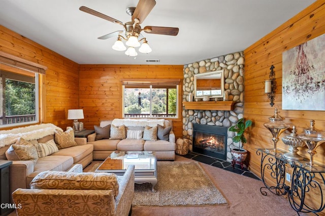 carpeted living room featuring ceiling fan and a fireplace