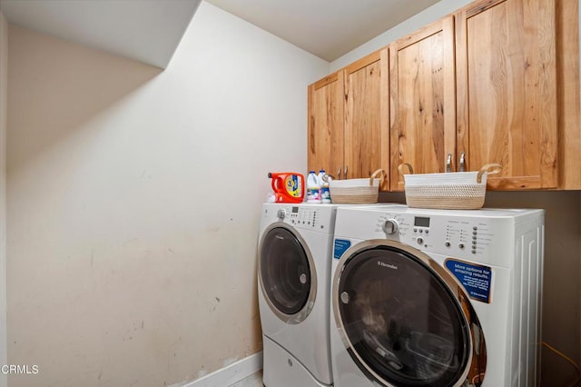 laundry area with washer and clothes dryer and cabinets