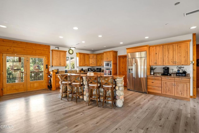 kitchen with light hardwood / wood-style floors, a center island, and built in appliances