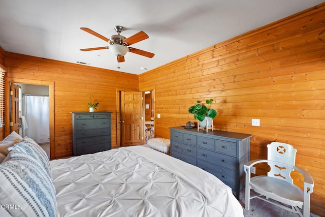 bedroom featuring ceiling fan and wooden walls