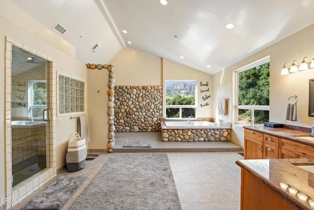 bathroom featuring vaulted ceiling, independent shower and bath, tile patterned flooring, and vanity