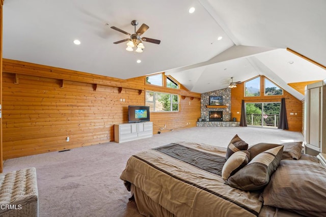 carpeted bedroom featuring ceiling fan, lofted ceiling, wood walls, and a fireplace