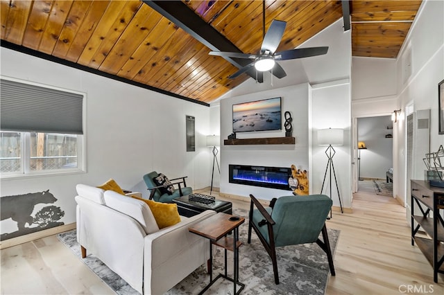 living room featuring lofted ceiling with beams, a large fireplace, light hardwood / wood-style floors, and ceiling fan