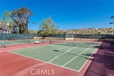 view of tennis court featuring basketball hoop