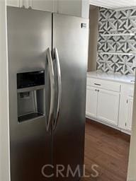 kitchen with stainless steel fridge, dark hardwood / wood-style flooring, and white cabinetry