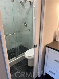 bathroom with toilet and a shower with door