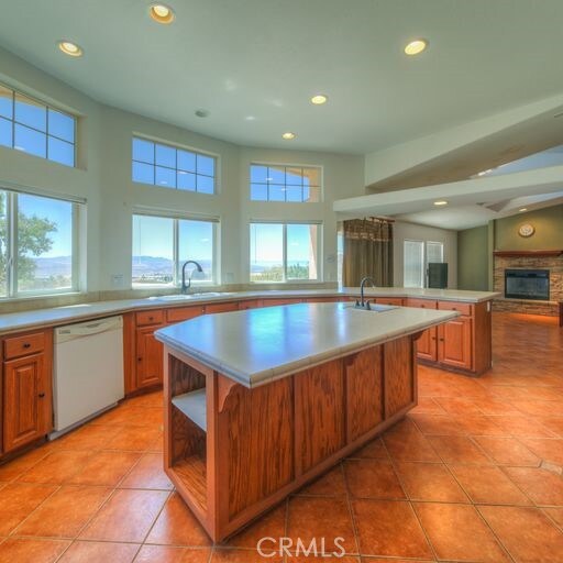 kitchen with dishwasher, a center island with sink, and sink