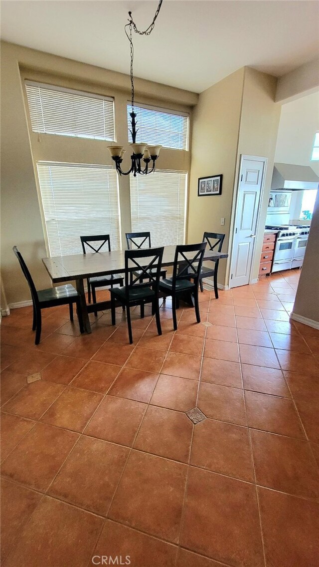 tiled dining space featuring a notable chandelier