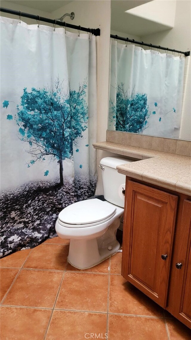 bathroom with vanity, tile patterned flooring, and toilet