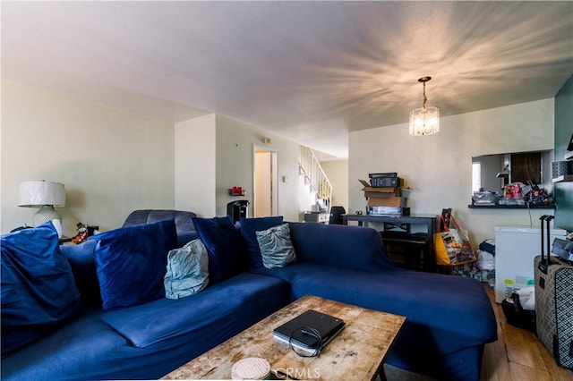 living room with hardwood / wood-style floors and a notable chandelier