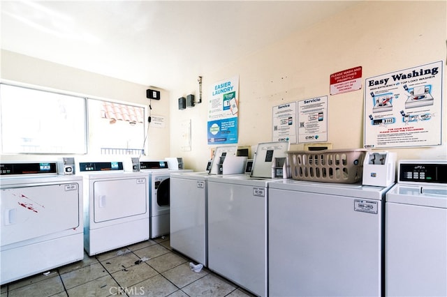 washroom with washing machine and clothes dryer and light tile patterned flooring