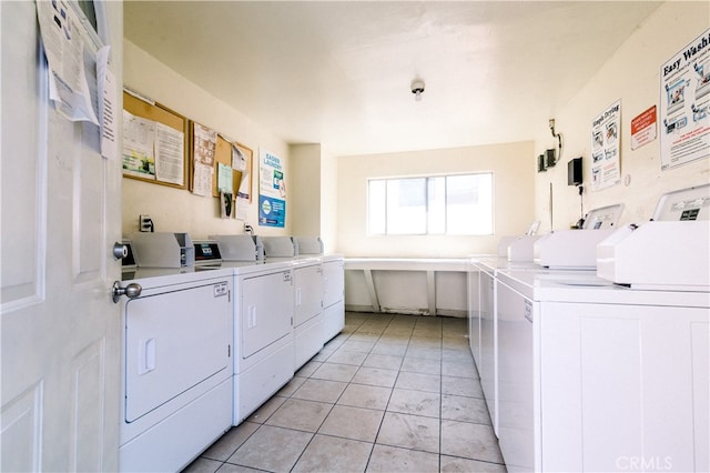 washroom with washer and clothes dryer and light tile patterned flooring