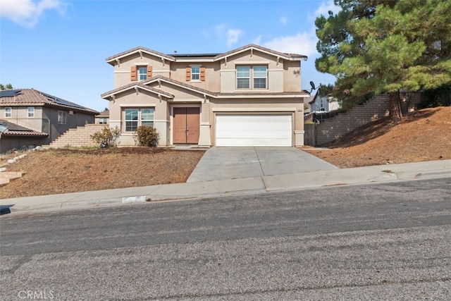 view of front of property featuring a garage, solar panels, fence, driveway, and stucco siding