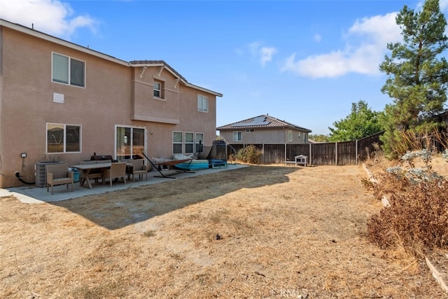 back of property with a patio area, fence, central AC, and stucco siding