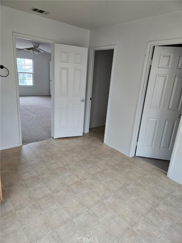 unfurnished bedroom with visible vents and light colored carpet