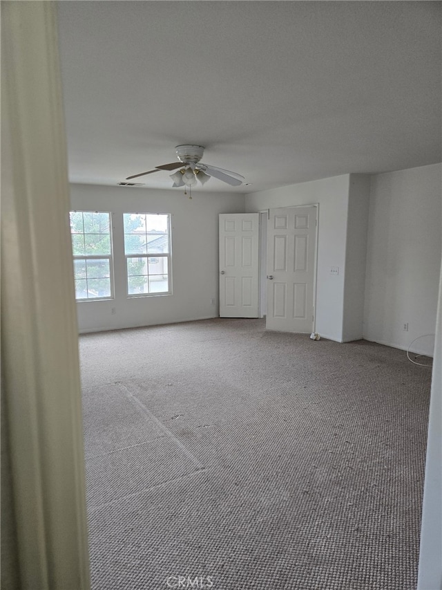 spare room featuring carpet floors and ceiling fan