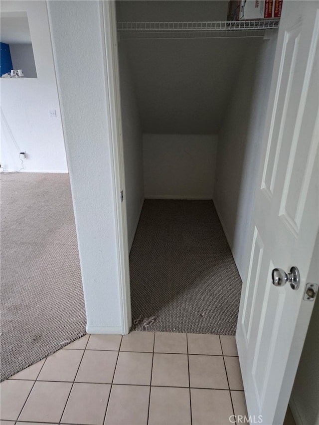 corridor featuring light carpet and light tile patterned floors