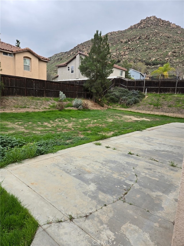 view of yard with a fenced backyard and a mountain view