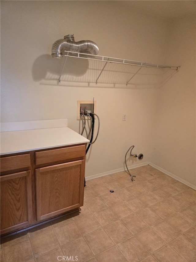 washroom featuring baseboards, washer hookup, cabinet space, and hookup for a gas dryer