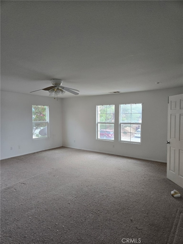 empty room with carpet floors and a ceiling fan