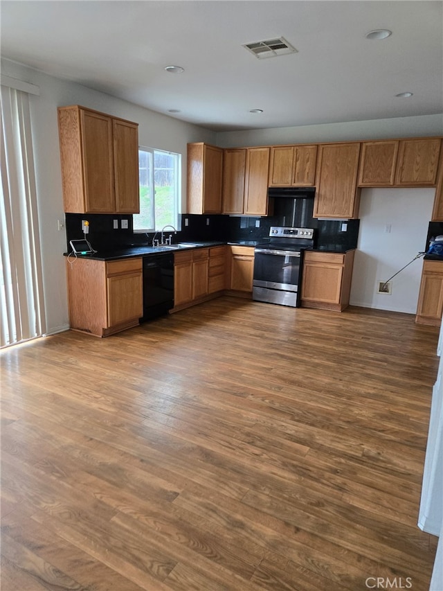 kitchen with visible vents, black dishwasher, stainless steel electric range, dark wood-style floors, and dark countertops