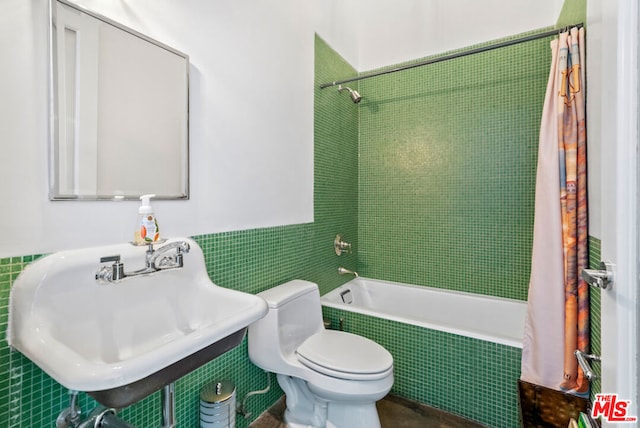 full bathroom with sink, toilet, shower / tub combo, and tile walls