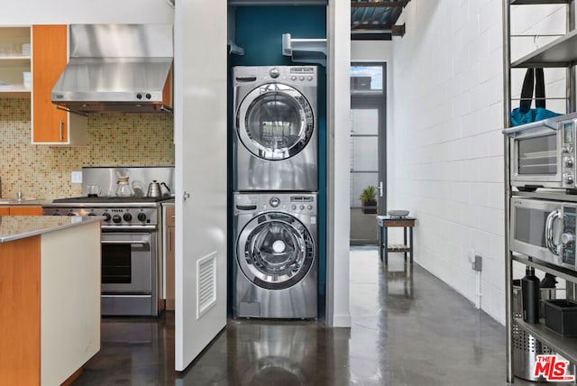 clothes washing area with stacked washer / drying machine