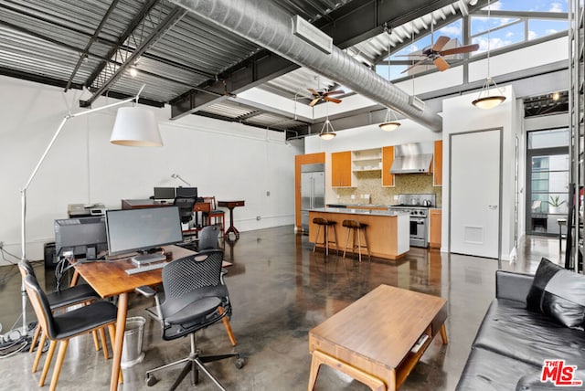 office space with a towering ceiling and ceiling fan