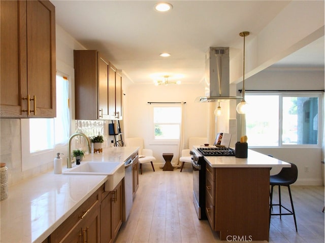 kitchen featuring island exhaust hood, pendant lighting, stainless steel appliances, and a wealth of natural light