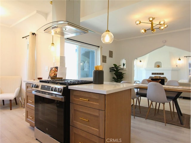 kitchen featuring light wood-type flooring, island range hood, gas range, and decorative light fixtures